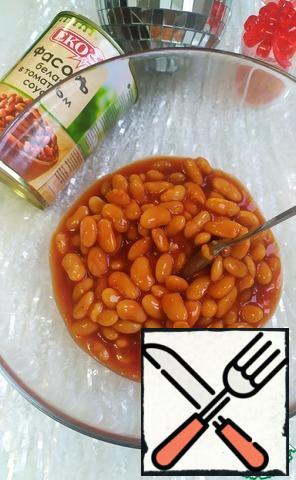 Open the canned white beans in tomato sauce and place in a large bowl for convenience.