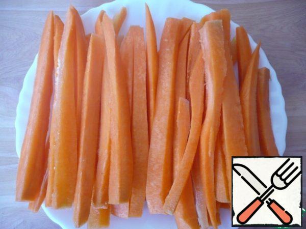 Wash the carrots, peel them, and cut them into long strips.