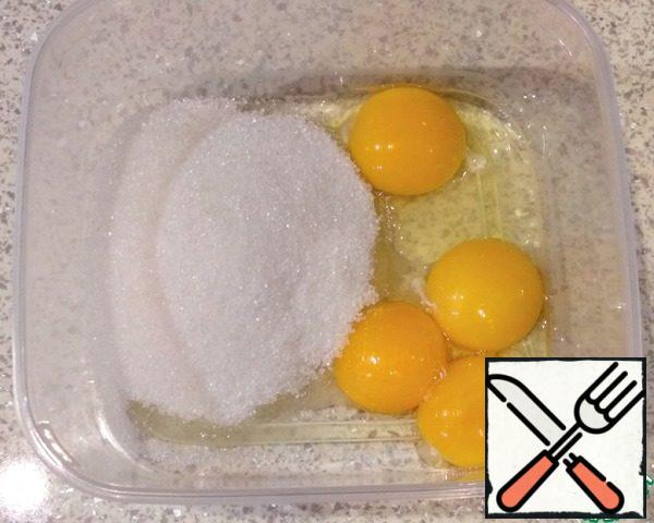 In a separate container, combine the sugar, yolks, and egg.