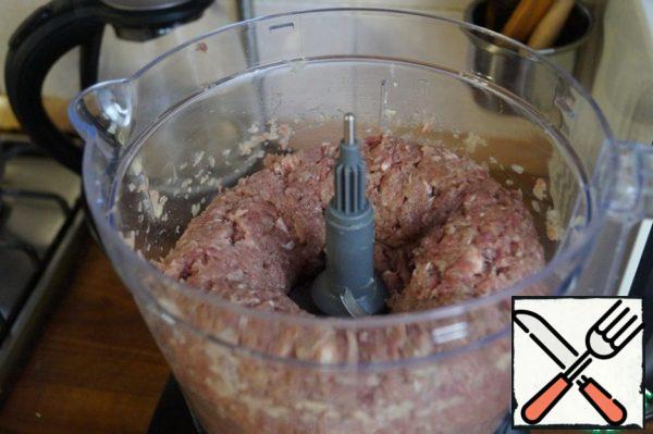 The flesh of the beef is washed and cut into pieces. Peel the onion and cut into slices. Put the meat and onions in the bowl of the combine. After 1 minute, we get a homogeneous minced meat.
