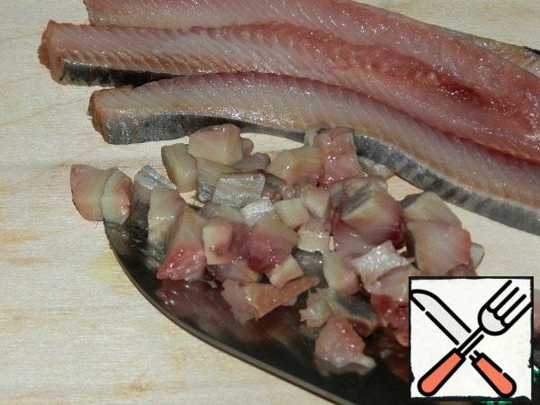 Cut half of the fillet of one lightly salted herring into small cubes.