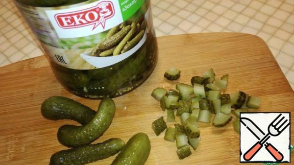 Cut the gherkins into cubes and send them to the onion.