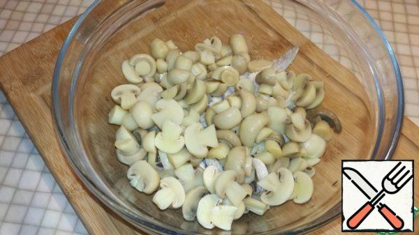 Cut the mushrooms in half and add to the bowl with the chicken.
