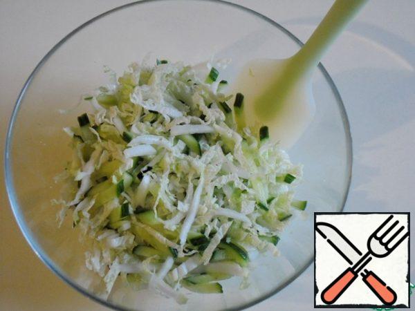 Put the cabbage in a bowl, add a little salt, add a pinch of sugar, and knead. Add the cucumbers and mix. Before assembling the salad, drain the resulting juice.