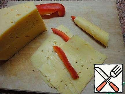 Cut the cheese into thin plates or take the ready-cut cheese. Put a slice of pepper in the middle, wrap it and the candle is ready.