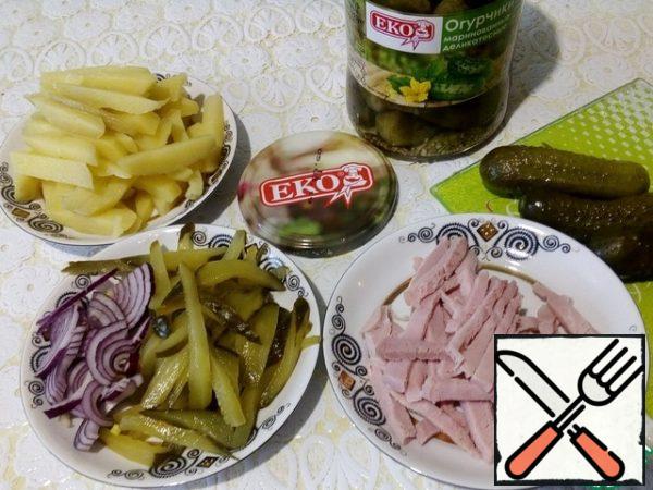 Boil the potatoes in advance in a "uniform", cool, peel. Cut potatoes, pickles, pork and onions into small cubes in half rings.
