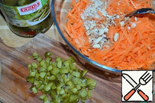Cut the gherkins, chop the almonds, add to the salad bowl.
