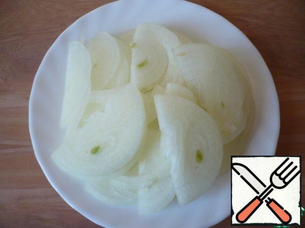 Peel the onion and cut into half rings.