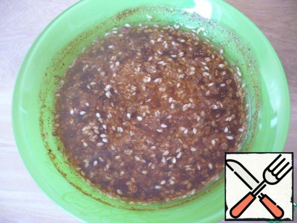 Now prepare the marinade for the herring: in a bowl, mix the chili pepper, nutmeg, coriander, ginger, sesame seeds, black pepper, sugar, soy sauce, cold water, table vinegar-9% and sunflower oil.