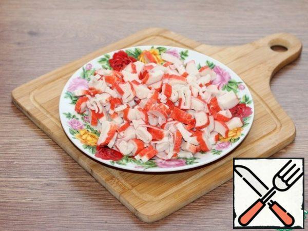 Defrost the crab sticks and cut into circles.
