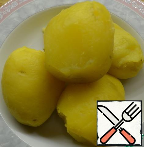 Boil the potatoes in their skins, peel and leave to cool.