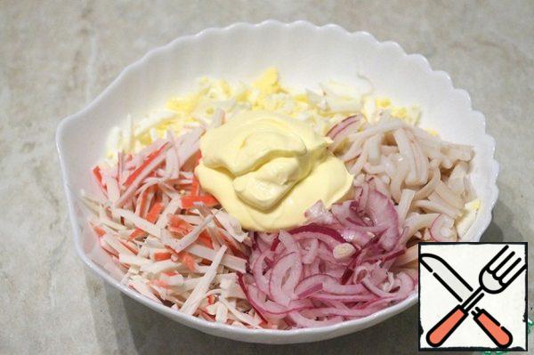 Put the onion, squid, eggs, and crab sticks in a deep bowl. Add mayonnaise, salt and mix.