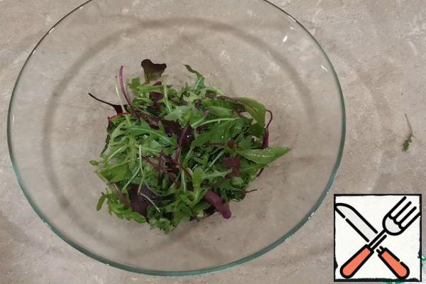 Put the mixture of lettuce leaves in a deep bowl.