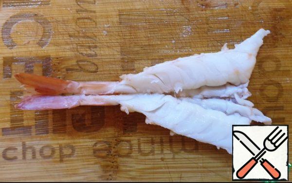 Boil the prawns in boiling water for 2 minutes. Remove the shrimps from the skewers and remove the shells, leaving only the tail. Put on the backs and cut from the side of the legs almost to the end. To clear from the esophagus, etc. if necessary.