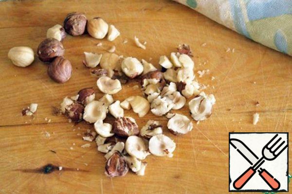 Coarsely chop the nuts or press the wide part of the knife blade.