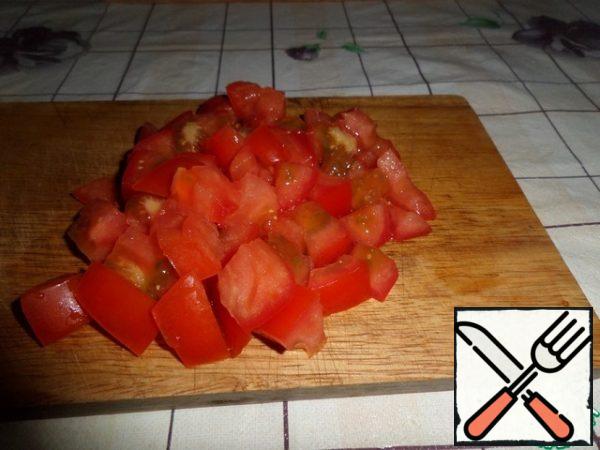 Wash the tomato and cut it into cubes.