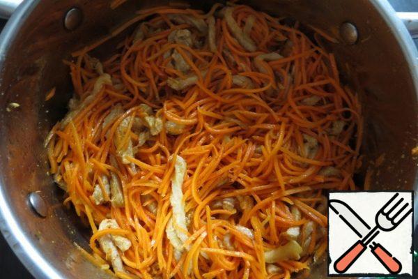Strongly squeeze the meat from the juice and put it on top of the carrots, pour in more boiling oil with fried onions, add the ready seasoning and crushed garlic. Mix well and leave to infuse at room temperature for 2-3 hours.