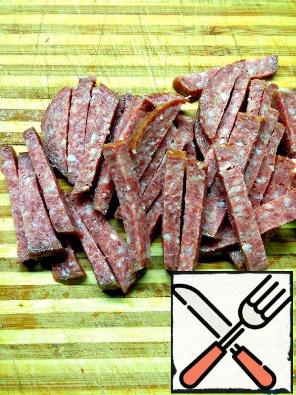 Cut the sausage into strips. To prepare this salad, you can use sausages, such as salami or servelat. To make the salad more piquant, you can add raw smoked sausage together with semi-smoked sausage.