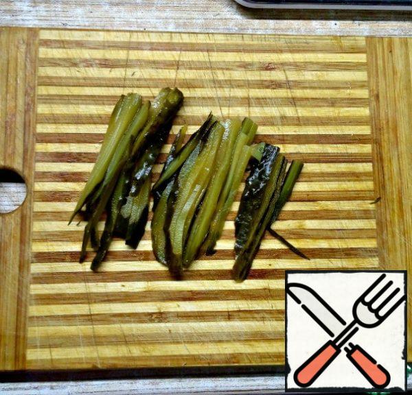 Cut pickles into strips.