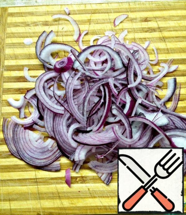 Peel the red onion and cut it into thin half-rings.