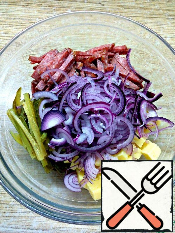 Combine the sausage, cheese, cucumbers and onions in a salad bowl.