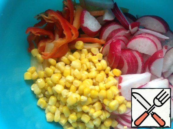 Pepper cut into strips, radish - half rings. Drain the excess liquid from the corn.