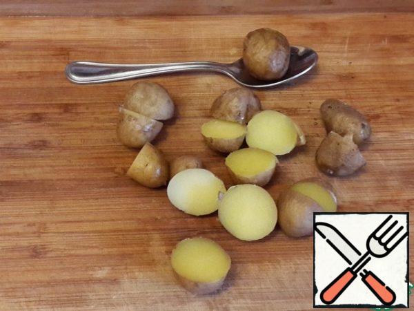 Boil small potatoes in their skins. Potatoes should not be larger than a quail egg. Cut into halves.