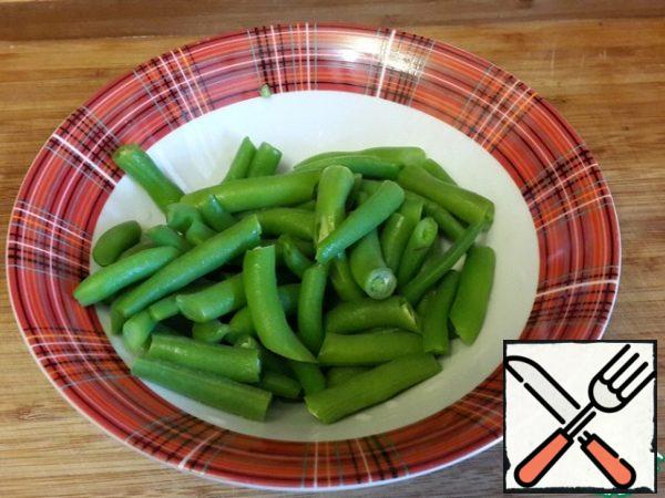 Blanch the string beans in boiling water for 5 minutes, drain the water and immediately put the beans in cold (or better, ice) water so that it retains its color. Drain the water and dry the beans on a napkin.