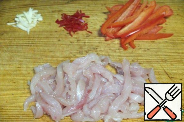 While the beans are thawed, cut into strips red hot pepper, bell pepper, garlic. Cut the chicken into thin strips.