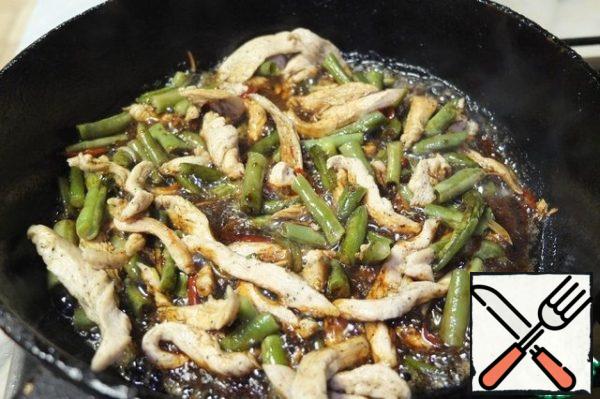 When the chicken is browned, pour in the soy sauce.