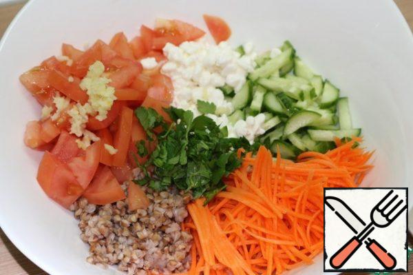 Grate the carrots on a Korean grater, cut the cucumbers into strips, and cut the tomatoes into small slices. Wash the greens, dry them and chop them. Finely chop the garlic.
Combine all the ingredients in a large salad bowl.