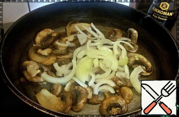 The products are prepared, the sauce is mixed, and now you can start roasting.
Pour 2 tablespoons of vegetable oil into the pan, heat, add the mushrooms and fry for 4 minutes over high heat (so that the mushrooms are fried, not stewed). Next, add the onion and fry for 3 minutes on high heat, stirring constantly.
