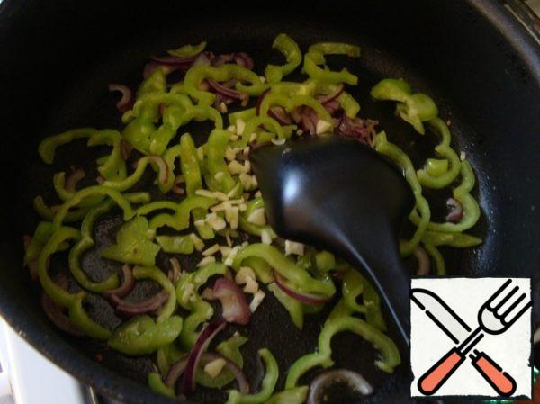 Pour the olive oil into the pan and put the garlic, onion, and then the peppers. Slightly fry.