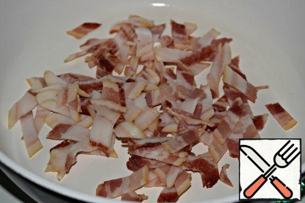 Cut the bacon slices into strips and heat over medium heat for 10 minutes. Put the bacon on a paper towel to remove excess fat.
