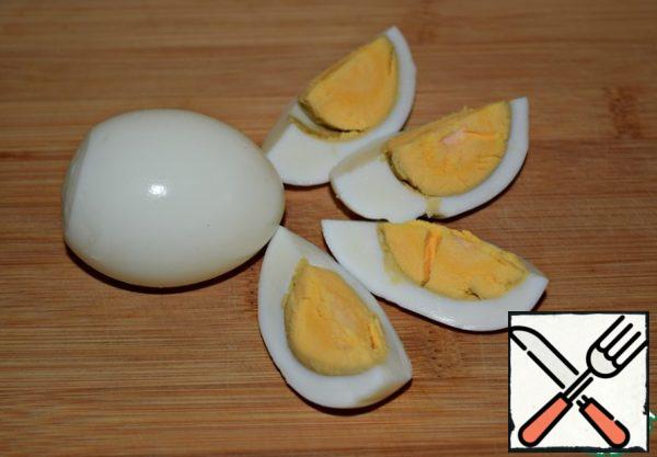 Peel the boiled eggs and cut them into quarters.