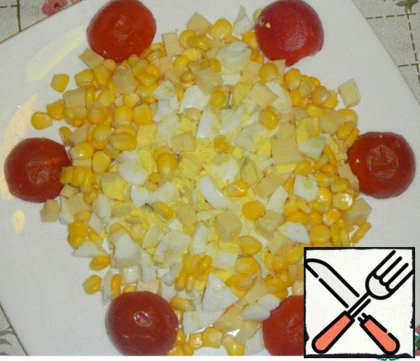 Drain the liquid from the corn. Boil the eggs, cut them quite large, cut the cheese into cubes, and cut each tomato in half. Arrange as your heart desires.