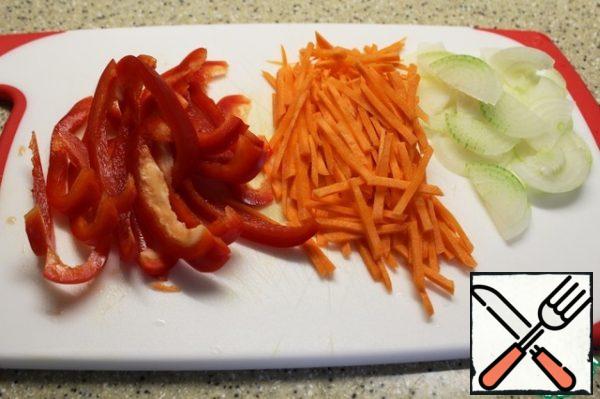 I cut the peppers and carrots into strips, and the onions into half-rings.