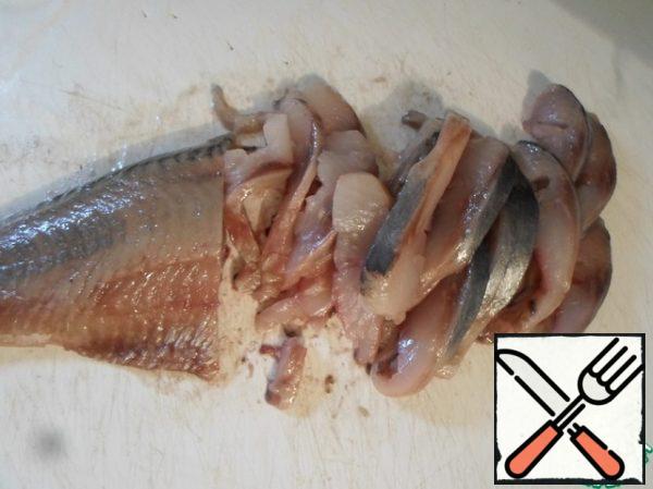 Cut the herring into very thin pieces.