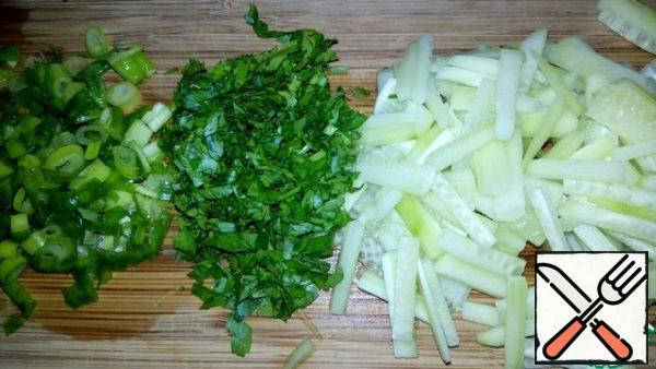 Wash the cucumbers and cut them into strips. Wash the green onions and parsley, dry and chop.