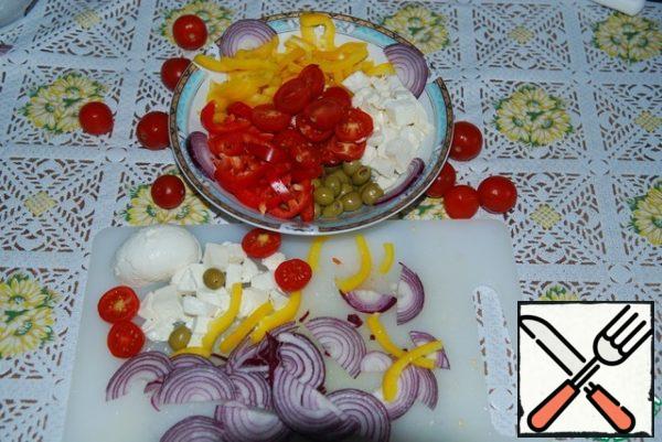Cut the onion into half rings.
Strips of pepper.
Cut tomatoes in half.
Cut the mozzarella into small cubes.
Put the olives whole.