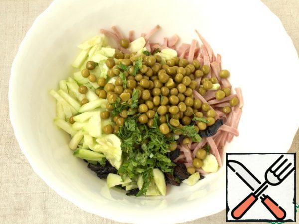 Put the cucumbers, ham and prunes in a deep bowl. Add canned green peas and finely chopped parsley. You can add more parsley than I do.