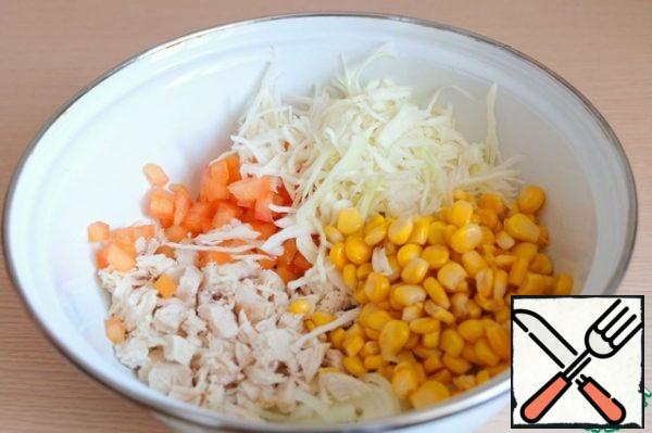 In a bowl, combine the chopped chicken fillet, onions, canned corn, tomatoes, shredded cabbage.
