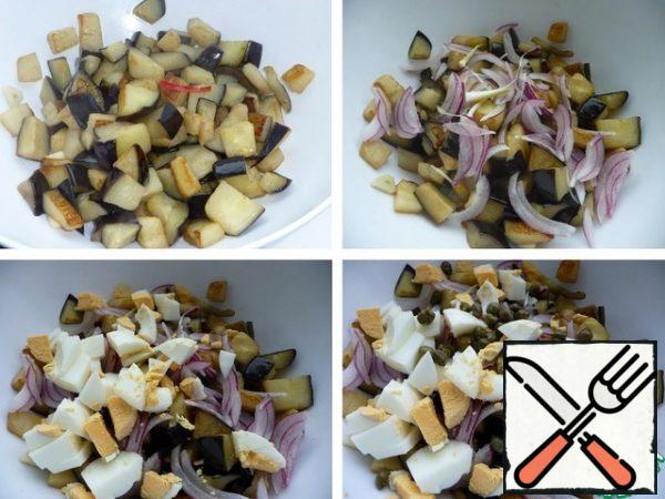 Transfer the fried eggplants to a bowl or salad bowl without the oil in which they were fried. Leave the eggplant to cool. Add the onion pressed from the marinade, diced egg, and capers. Gently mix.