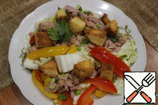 Cut clean and dried from moisture Peking cabbage into large squares.
For the dressing, mix the salt, pepper, vinegar and oil in a bowl until the salt dissolves.
Mix the cabbage with the peppers and dressing.
Put the skinless and boneless tuna and crackers on the salad.