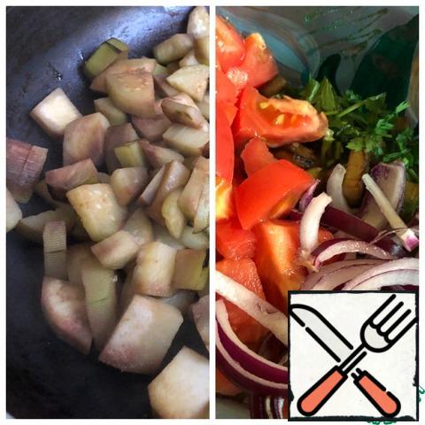Peel the eggplant and cut into medium cubes. Fry until tender, and throw in a colander to remove excess oil. Put the cooled eggplant in a salad bowl. Add the tomato cut into medium cubes and finely chopped herbs. Cut the onion into half rings.