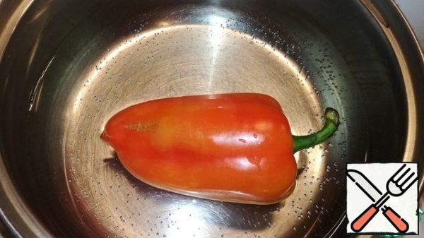 Pour water into a saucepan and bring to a boil. Put the bell pepper in a pan and cook for 5-7 minutes. Remove, cool and peel.