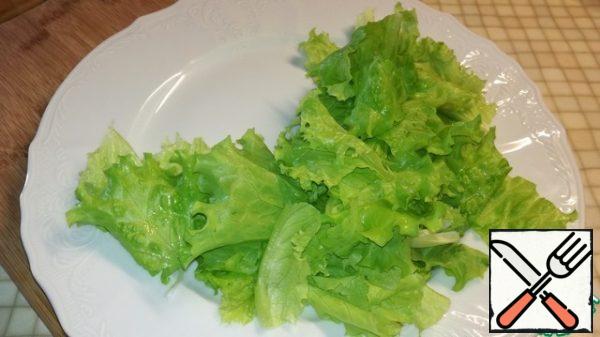 Tear the lettuce leaves arbitrarily with your hands and put them on a serving dish.