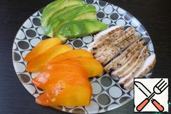 Cut the avocado, persimmon and chicken fillet into thin slices. It is advisable to sprinkle the avocado with lemon juice so that it does not darken.