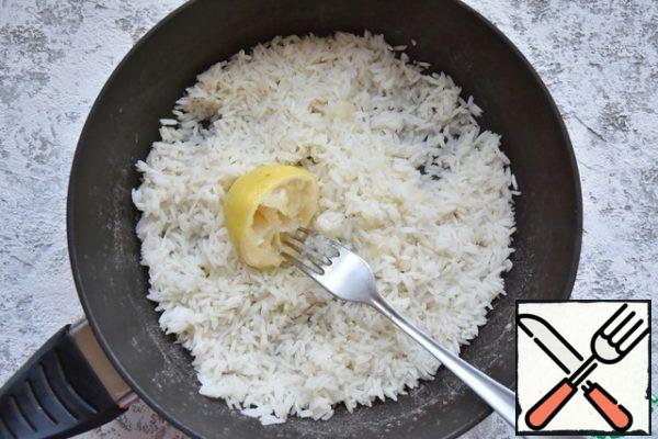 Cover the pan with a lid and leave the rice on medium heat for 10 minutes.
After the time has elapsed, the water will be completely absorbed into the rice. Turn off the heat and lightly loosen the rice with a fork. Squeeze the lemon pulp over the rice and mix.