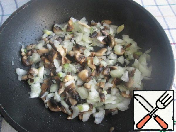 First you need to prepare the bulbs by cutting off the upper part of each. Then cut the middle so that 2 outer layers remain (the photo of the resulting onion barrels is given below in the recipe).
Then blanch the onion barrels in boiling water for 5 minutes (to remove the bitterness), remove from the water and cool slightly.
Cut the onion peeled from the middle and fry it in vegetable oil with finely chopped mushrooms